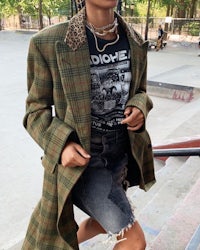 a woman wearing a plaid blazer and denim shorts