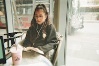 a girl is sitting at a table reading a book